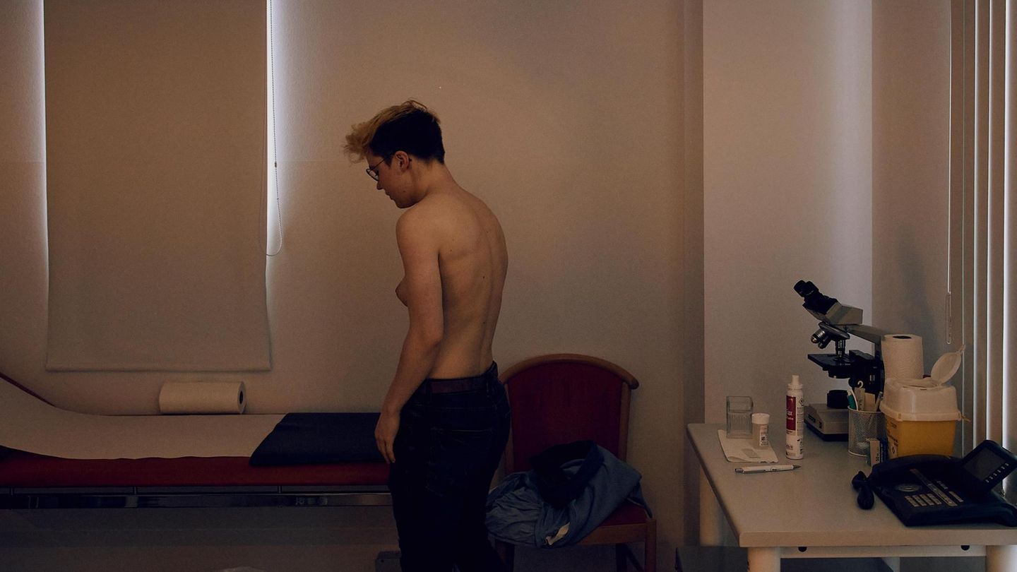 Lennart steht oberkörperfrei im Behandlungszimmer einer Arztpraxis