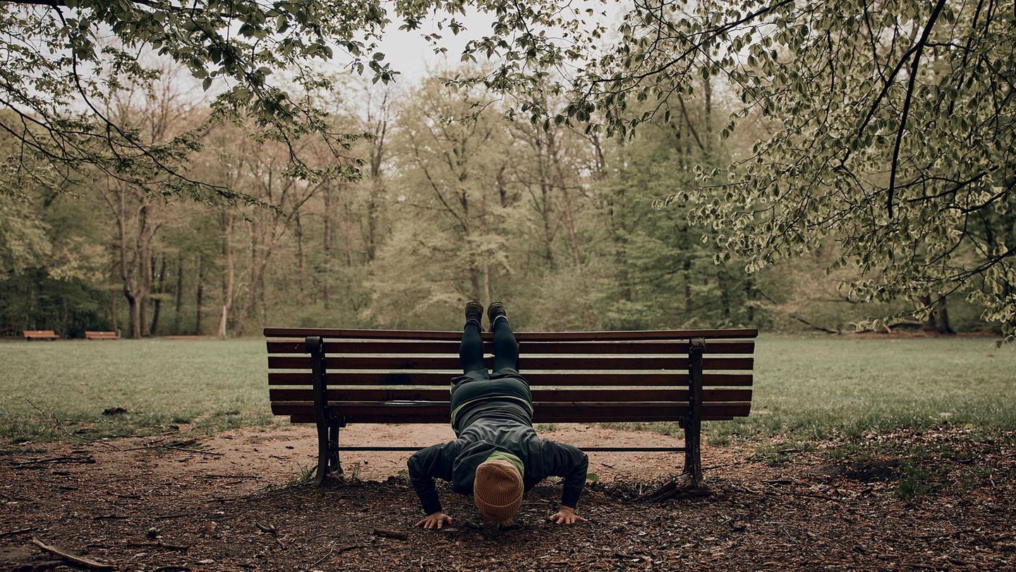 Lennart macht Liegestütz an einer Bank in einem Park