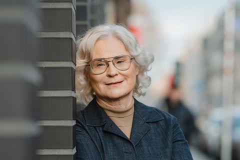 Portrait von Christine Lambrecht an einer Wand lehnend