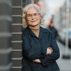 Portrait von Christine Lambrecht an einer Wand lehnend