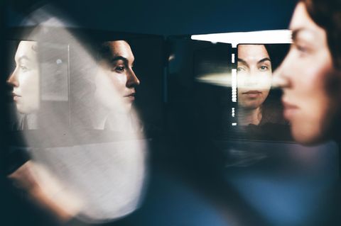 Eine Frau schaut sich in mehreren Spiegeln an – Perfektionismus