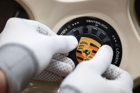 Ein Mitarbeiter arbeitet an einem Porsche