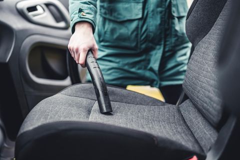 Eine Frau saugt ihr Auto aus