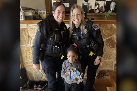 Dez'Riel und zwei US-amerikanische Polizistinnen machen ein Foto nach dem das Kleinkind sie gerufen hat
