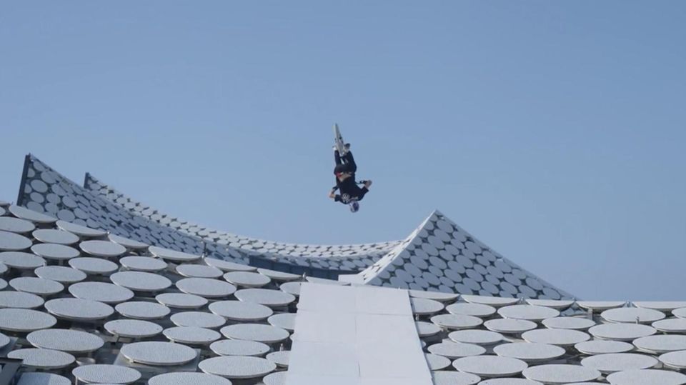 Mountainbiker Fabio Wibmer macht einen Backflip auf dem Dach der Elbphilharmonie