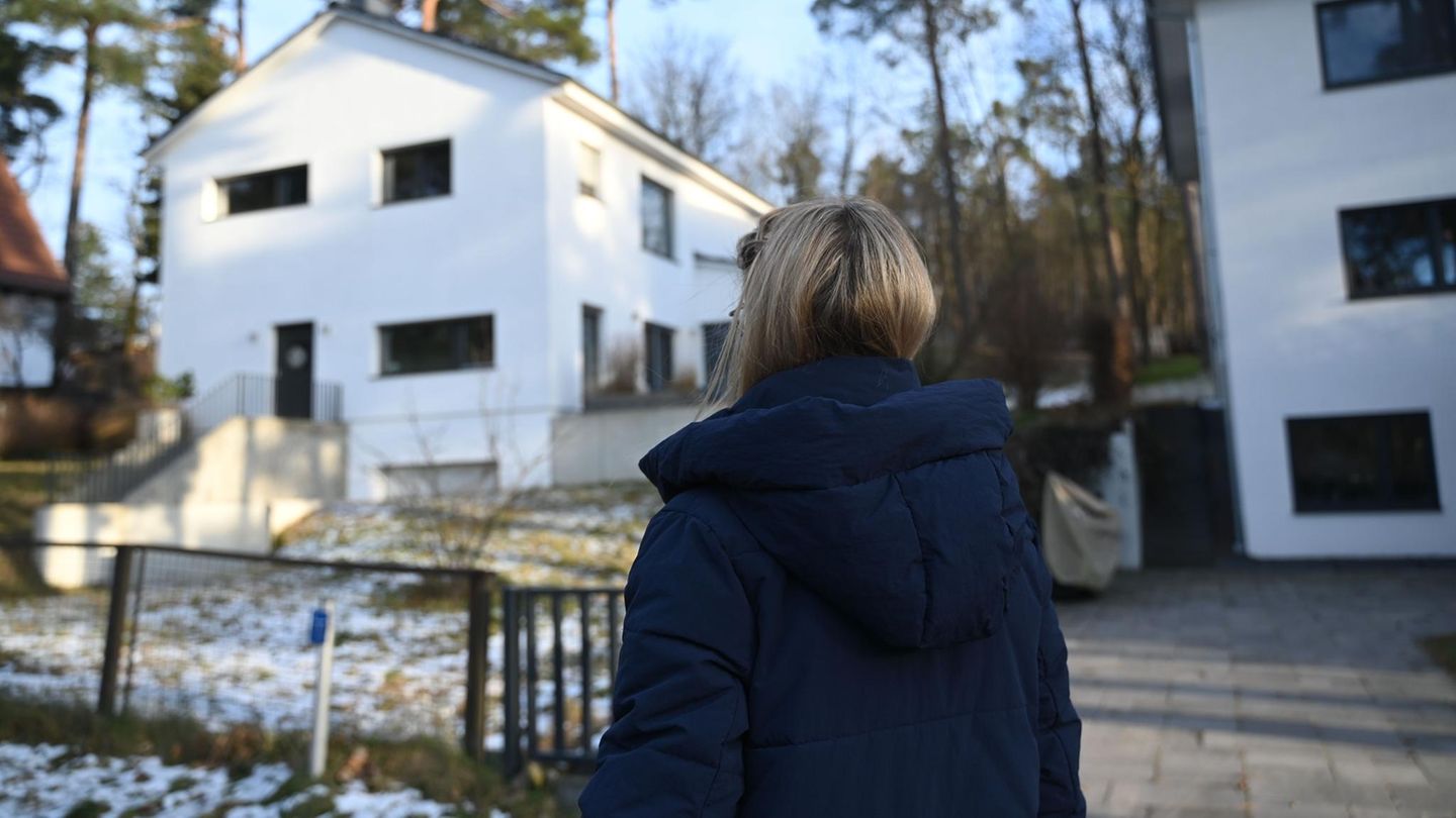 Frau W., zu sehen ist ihr Hinterkopf, steht vor ihrem modern, neuen Haus in Rangsdorf