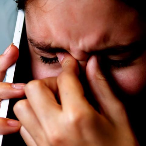 Weinendes Mädchen mit Smartphone am Ohr