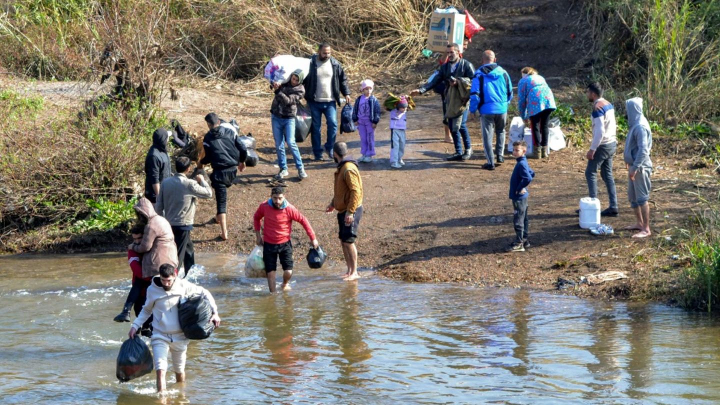 Menschen fliehen über die syrisch-libanesische Grenze
