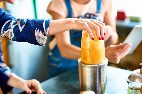 Frau benutzt einen Standmixer
