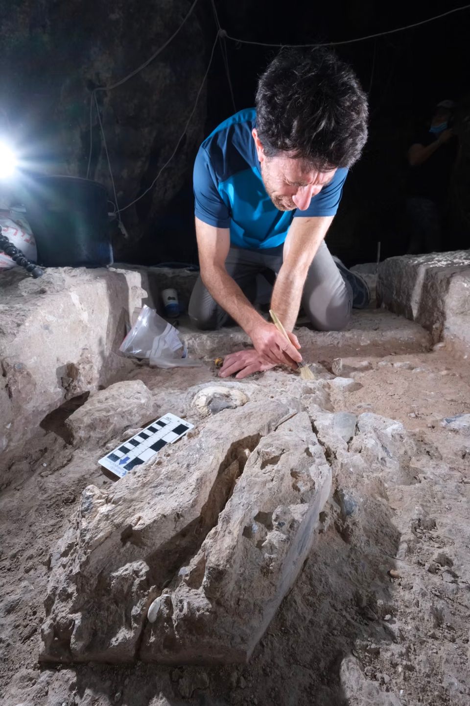 Ein Archäologe präpariert mit einem Pinsel mehr als 100.000 Jahre alte Gebeine Ein Archäologe präpariert mit einem Pinsel mehr als 100.000 Jahre alte Gebeine