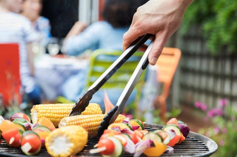 Ein Mann grillt Germüse