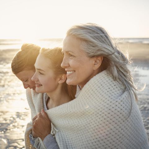 Mutter, Tochter, Großmutter stehen am Strand – gemeinsam eingewickelt in ein Tuch ist auch die Mütterrente ein Thema