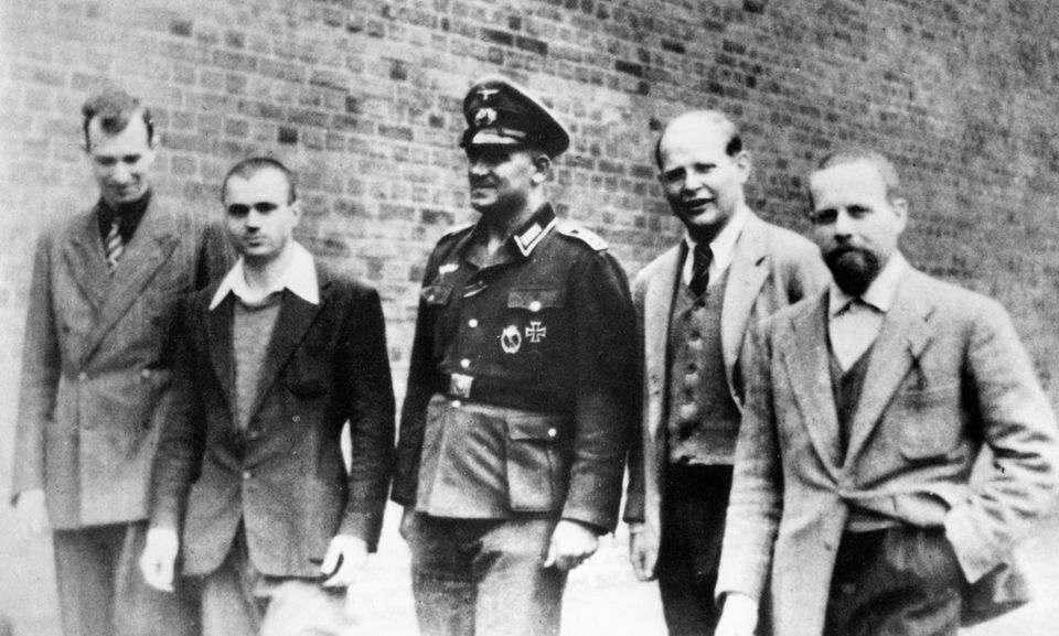 Schwarzweißfoto einer Gruppe von fünf Männern, der mittlere in Uniform Schwarzweißfoto einer Gruppe von fünf Männern, der mittlere in Uniform