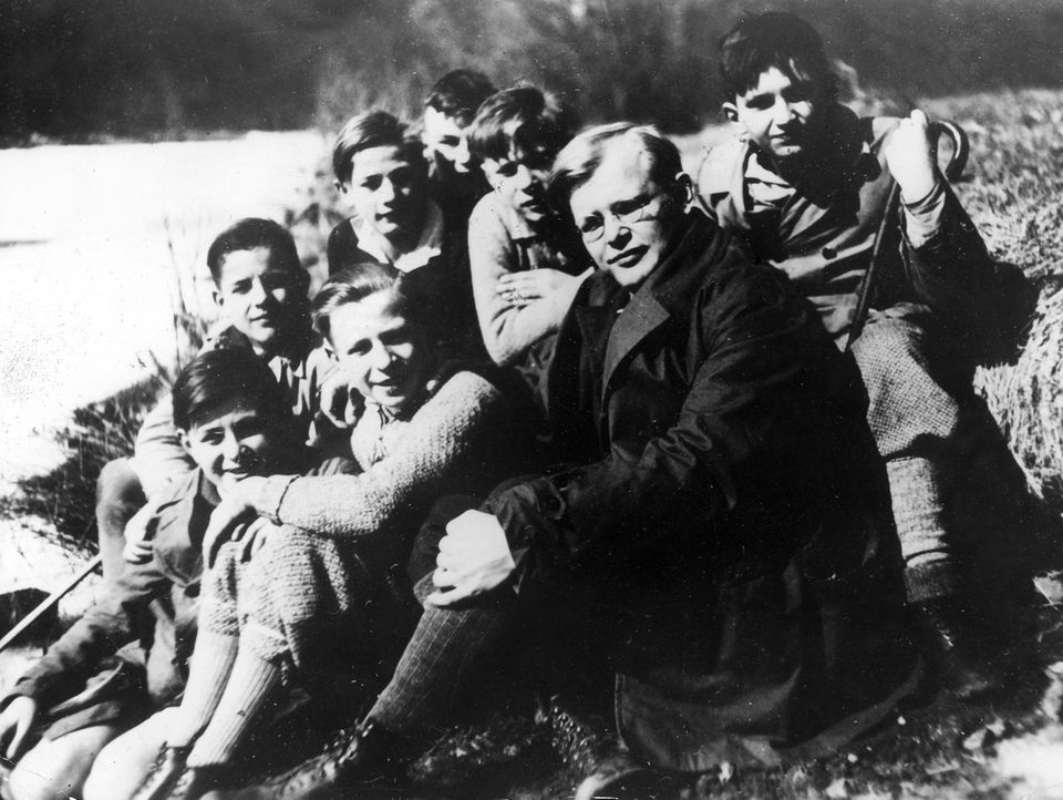 Dietrich Bonhoeffer sitzt umringt von Jugendlichen im Freien Dietrich Bonhoeffer sitzt umringt von Jugendlichen im Freien