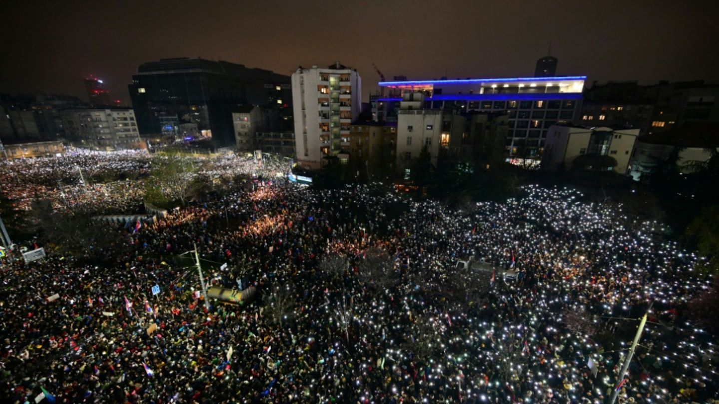 Gedenken an Opfer von Novi Sad: Protestierende halten Handys in die Höhe