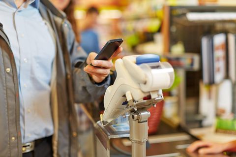 Bargeld: Ein Mann zahlt per Smartphone