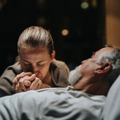 Thema Lebensende: Eine Frau hält die Hand eines Sterbenden