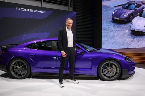 VW-Vortstand Oliver Blume steht vor einem Porsche