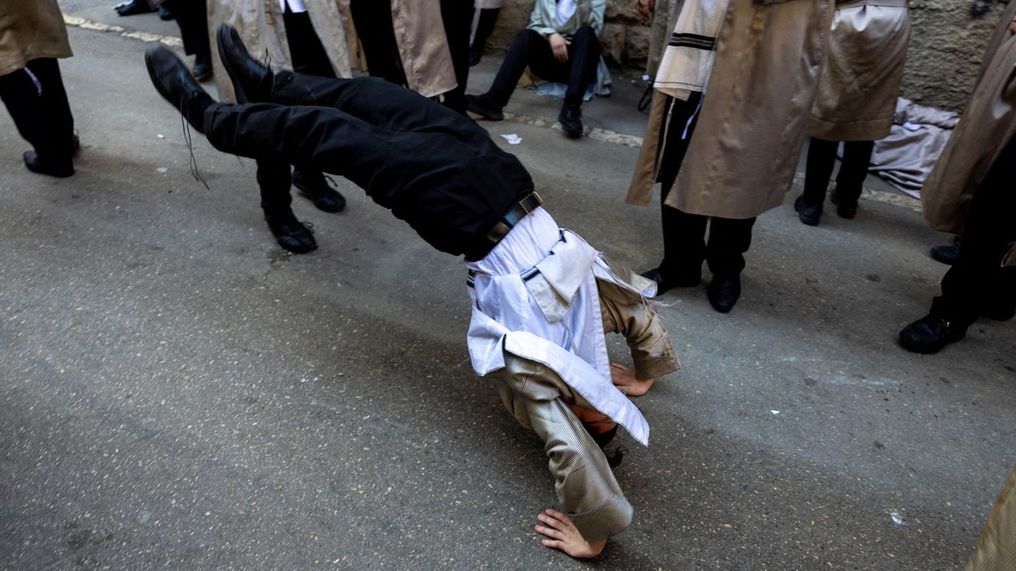 Jüdisch ultraorthodoxer Mann macht Salto rückwärts während eines Tanzes in den Strassen von Jerusalem