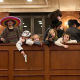 Jüdische ultraorthodoxe Männer und Kinder, von denen einige Kostüme tragen, halten sich in einer Synagoge in Jerusalem auf