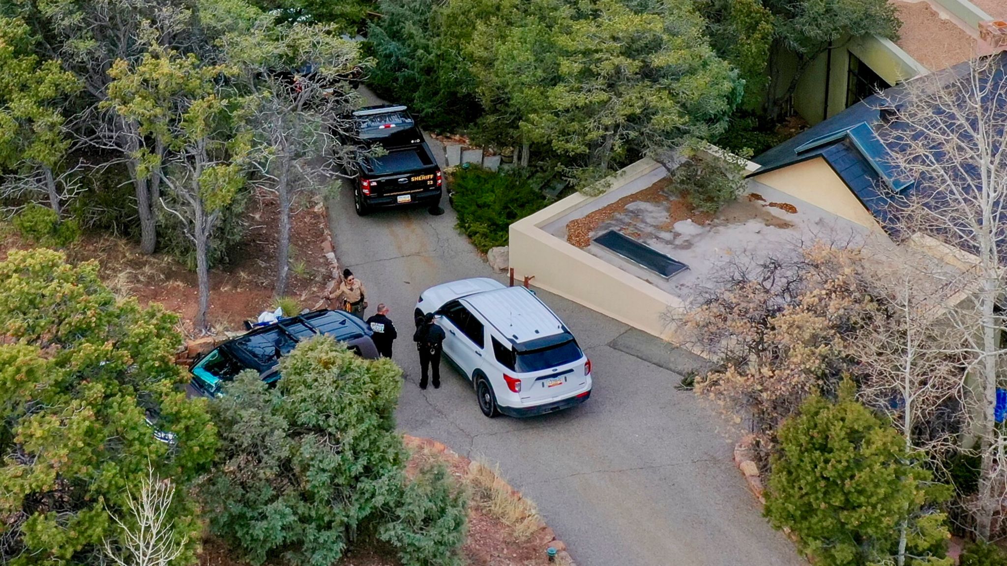 Ermittler besprechen sich vor dem Luxus-Anwesen in einer Gated Community von Santa Fe, wo Gene Hackman und seine Frau Betsy Arakawa tot aufgefunden wurden, 27. Februar 2025