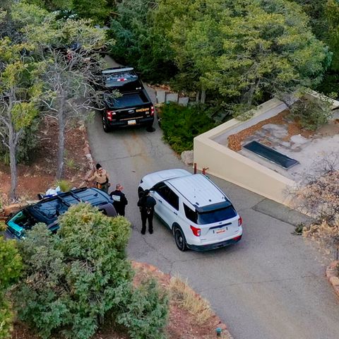 Ermittler besprechen sich vor dem Luxus-Anwesen in einer Gated Community von Santa Fe, wo Gene Hackman und seine Frau Betsy Arakawa tot aufgefunden wurden, 27. Februar 2025