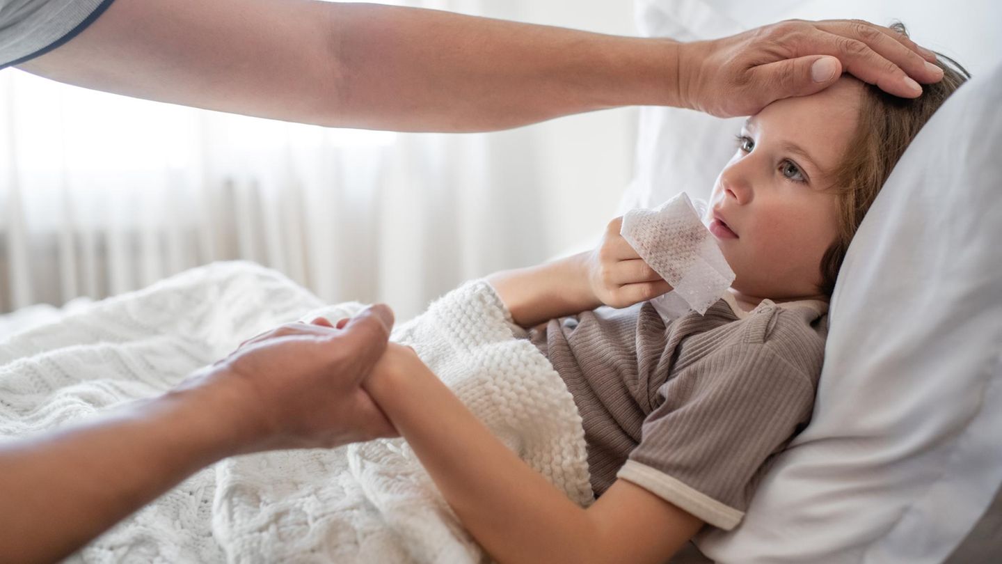 Ein an Grippe beziehungsweise Influenza erkranktes Kind liegt in einem Bett