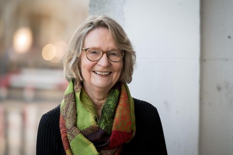 Kirsten Boie im Portrait. Sie trägt kinnlanges Haar, eine braune Brille und einen grünen Schal