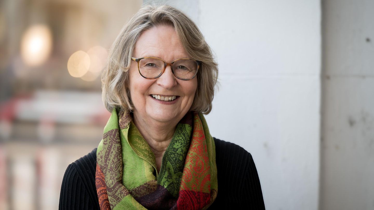Kirsten Boie im Portrait. Sie trägt kinnlanges Haar, eine braune Brille und einen grünen Schal