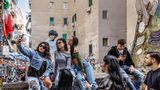 Drei junge Frauen machen ein Selfi vor dem Wandbild von Diego Maradona in Neapel