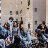 Drei junge Frauen machen ein Selfi vor dem Wandbild von Diego Maradona in Neapel