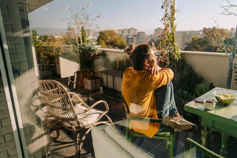 Dopamin-Fasten: Frau entspannt auf dem Balkon