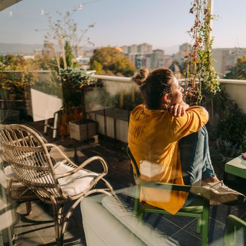 Dopamin-Fasten: Frau entspannt auf dem Balkon