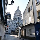 Blick auf die pariser Kirche Sacré-Coeur zwischen den Häusern einer Gasse hindurch