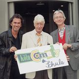 Hugo Egon Balder und Rudi Carrell halten ein Schild der "Kölner Comedy Schule" hoch