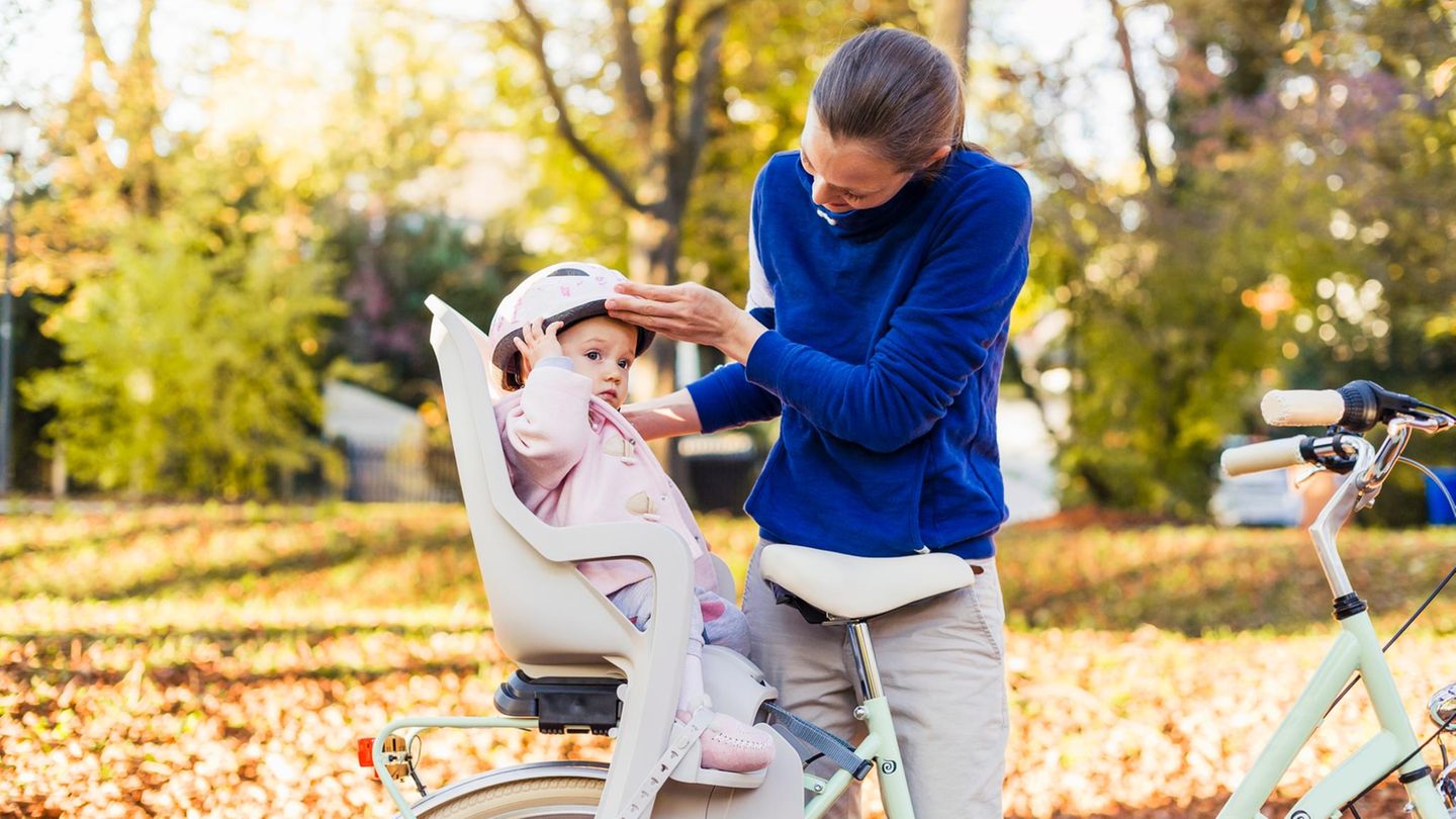 Kleinkind im Fahrradkindersitz mit Helm auf dem Kopf