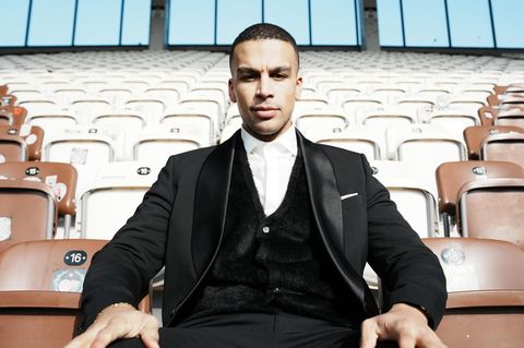 Booz sitzt auf Stadionstühlen.