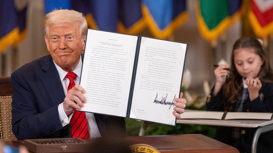 Donald Trump hält ein neues Dekret zum Abbau des US-Bildungsministeriums hoch
