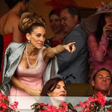 Parker mit eleganter Turmfrisur auf der Tribüne bei einem Pferderennen