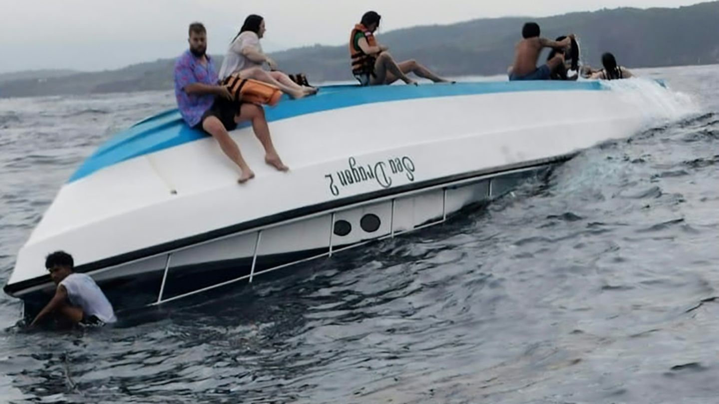 Überlebende sitzen auf dem gekenterten Boot