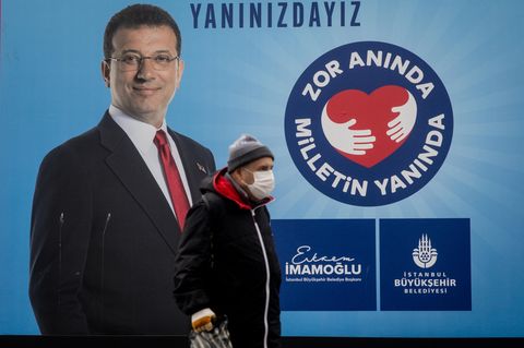 Ein Mann geht an einem Plakat von Ekrem Imamoglu vorbei