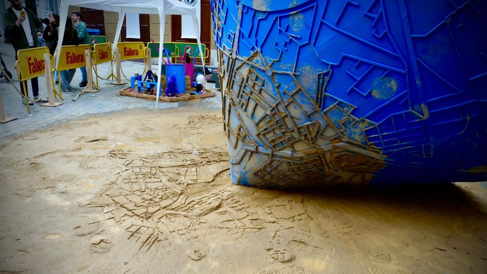 Spanien: Ein Kreisel zeichnet eine Karte der überfluteten Gebiete in den Sand Ein Kreisel zeichnet eine Karte der überfluteten Gebiete in den Sand