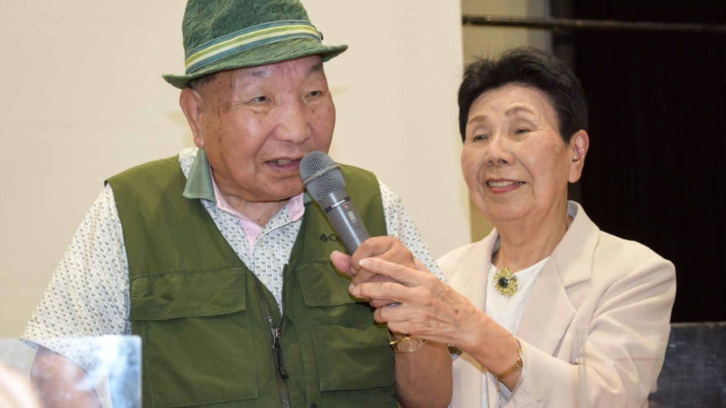 This photo taken in September 2024 shows Iwao Hakamada (L) speaking as his 91-year-old sister Hideko holds the microphone