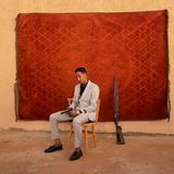 Der Bräutigam posiert mit einer Waffe für ein Porträt auf seiner Hochzeit