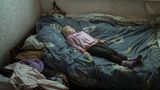 Anhelina (6), die traumatisiert ist, liegt in ihrem neuen Zuhause im Bett