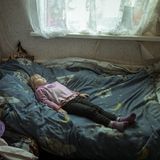 Anhelina (6), die traumatisiert ist, liegt in ihrem neuen Zuhause im Bett