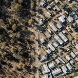 Eine Luftaufnahme von neu errichteten Häusern neben der Zaunlinie des Mosi-oa-Tunya-Nationalpark