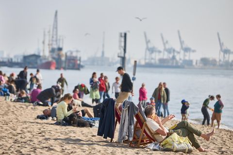 Menschen hängen in ihrer Freizeit am Elbstrand ab.