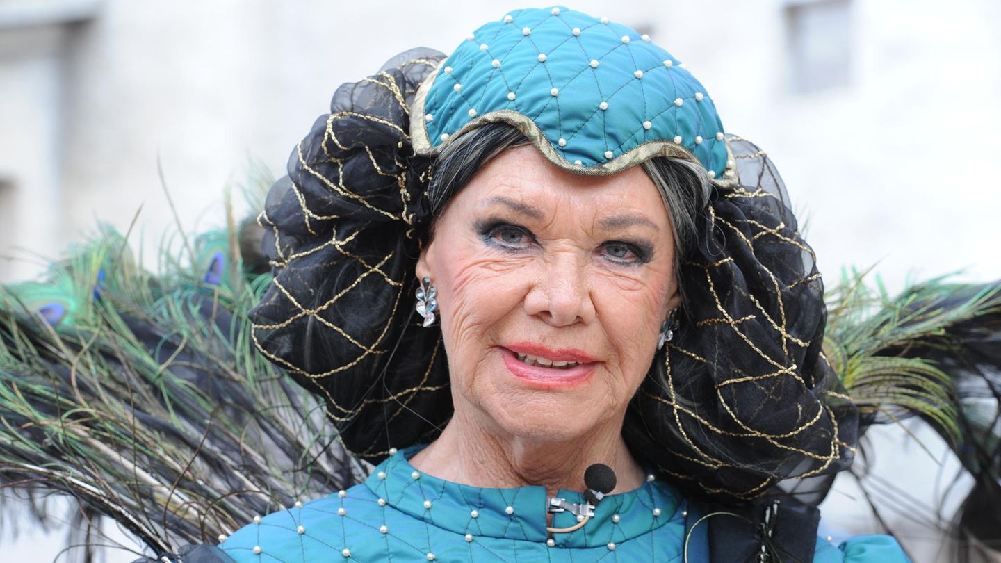 Iris van Bergen im Kostüm der Signorra de Rocca, blaues Kleid, Pfauenfedern und Haarnetz