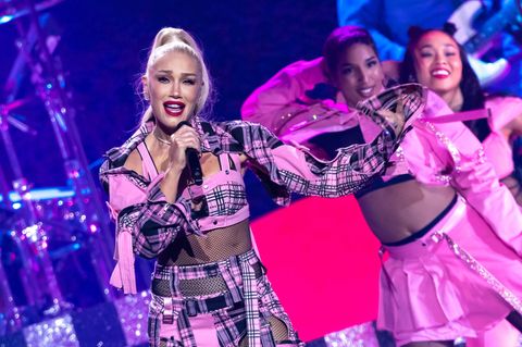 Gwen Stefani steht in einem pinken Outfit auf der Bühne und singt